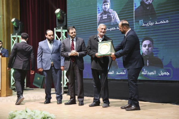 DAMASCUS, SYRIA - DECEMBER 6, 2025: Ministers and high-ranking officials of the newly formed Syrian government attend a symbolic ceremony to honor the families of victims who lost their lives during the Syrian war. The event, held in the capital Damascus, aims to provide social and symbolic recognition to the relatives of those fallen during the conflict as part of the country's transitional or commemorative phase, Damascus, Damascus, Syria