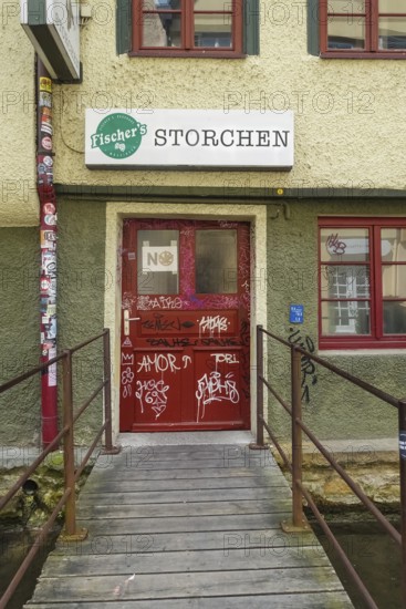 Pub, stork, traditional restaurant, beer pub on the river Ammer, red front door, graffiti, bridge, Tübingen, Baden-Württemberg, Germany
