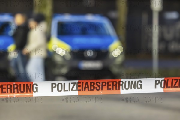 Flutter tape with the inscription police barrier. Behind it, a police car. Stuttgart, Baden-Württemberg, Germany