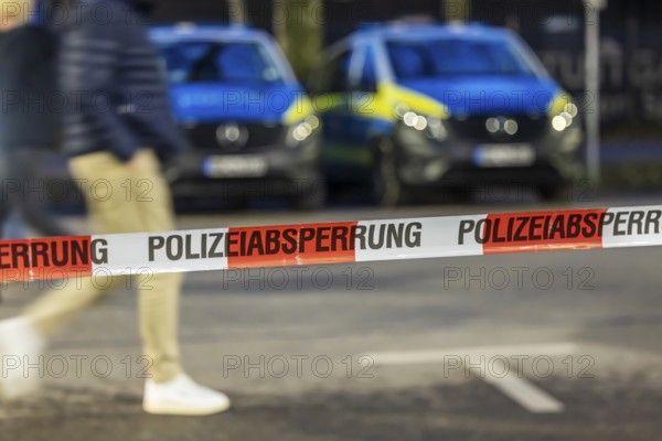 Flutter tape with the inscription police barrier. Behind them, police vehicles. Stuttgart, Baden-Württemberg, Germany