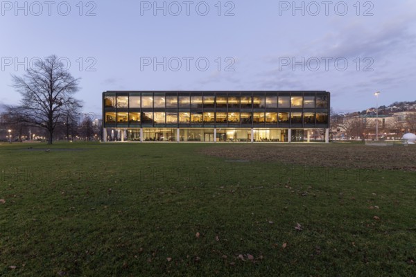 The state parliament of Stuttgart glows impressively in the evening. The architecture is accentuated by the night light and creates a clear, atmospheric atmosphere