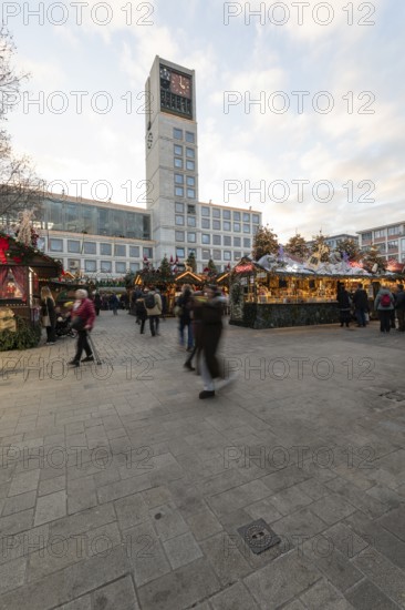 The Christmas market on the market square, in front of Stuttgart City Hall 2025, shines in festive lights in the evening. Many people visit the stands and enjoy the Christmas atmosphere