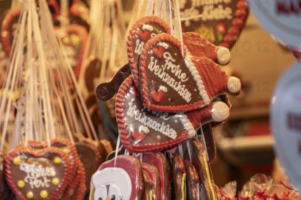 Colourful gingerbread hearts hang on the festive stands at the Stuttgart Christmas market. They are a popular sweet treat and embody the Christmas atmosphere. The selection is large and invites you to feast and give as a gift