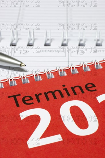 Red calendar with silver pen and spiral binding, diary