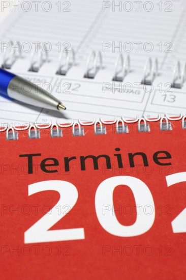 Vertical photographed calendar with blue pen and red cover, diary