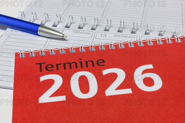 2026 calendar with red cover, blue pen and spiral binding, diary