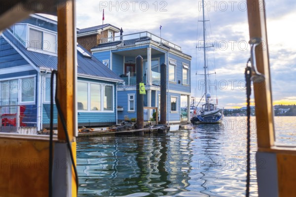 Fisherman's wharf park is a floating community of colorful houses and shops in victoria, british columbia, with sailboats passing by, during a beautiful summer day