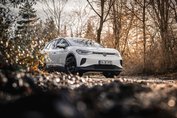 Car in an autumn forest landscape with bare trees, VW ID4 electric car, Deer Carsharing, Calw, Germany
