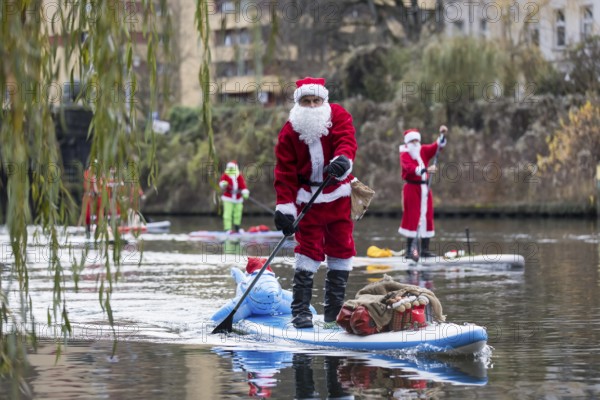 Water sports enthusiasts dressed up as Santa Claus ride SUPs on the Spree in Berlin on 30.11.2025