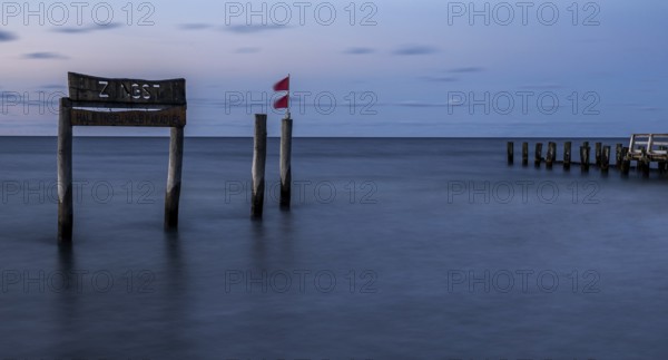 Wooden sign in the sea with inscription Zingst and Buhnen, long exposure, evening light, Zingst, Fischland-Darß-Zingst, Western Pomerania National Park, Mecklenburg-Western Pomerania, Germany