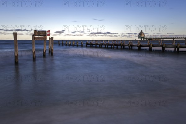 Wooden sign in the sea with inscription Zingst and wooden walkway, pier with diving gondola behind, panorama, long exposure, evening light, Zingst, Fischland-Darß-Zingst, Western Pomerania Lagoon Area National Park, Mecklenburg-Western Pomerania, Germany