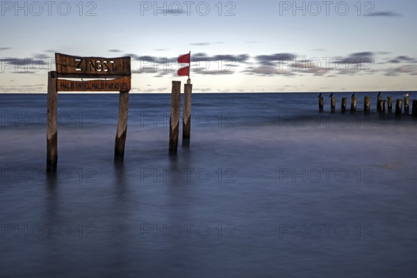 Wooden sign in the sea with inscription Zingst and Buhnen, long exposure, evening light, Zingst, Fischland-Darß-Zingst, Western Pomerania National Park, Mecklenburg-Western Pomerania, Germany