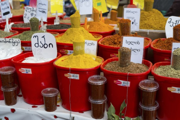 A colorful market stand with red buckets full of various spices and Georgian labels, Akhaltsikhe market, Samtskhe-Javakheti region, Samtskhe-Javakheti, Georgia