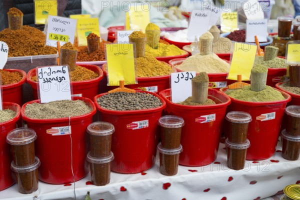 A market stall with red buckets full of colorful spices and Georgian lettering, Akhaltsikhe market, Samtskhe-Javakheti region, Samtskhe-Javakheti, Georgia