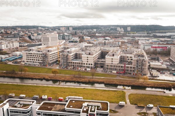 New hospital aerial view of an area with modern buildings, a river and a large construction site, Böblingen, Germany