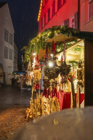 Sales stand at the Christmas market with wooden decorations and lights in the rain at night, Böblingen Christmas market, Germany