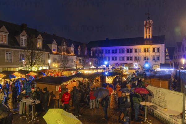 Busy Christmas market at night with bright lights and rainy atmosphere, Böblingen Christmas market, Germany
