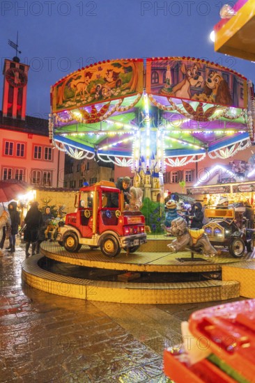 Colourfully lit children's carousel with vehicles at a Christmas market in the evening, Böblingen Christmas market, Germany