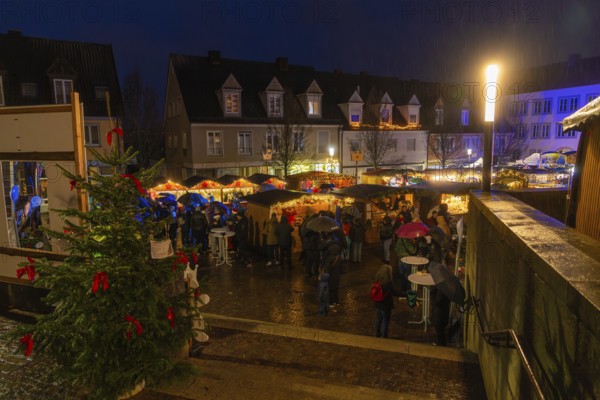 Christmas market at night, lots of visitors with umbrellas, Christmas tree and bright lights, Böblingen Christmas market, Germany
