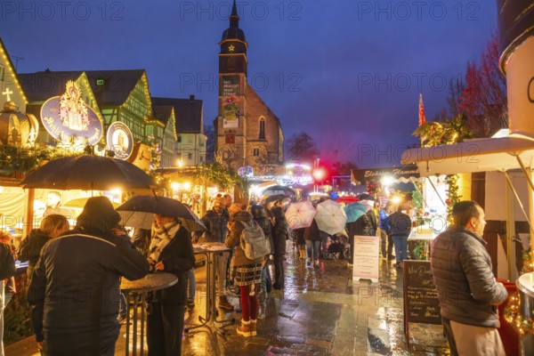 People with umbrellas and festive lighting at a Christmas market at night, Böblingen Christmas market, Germany