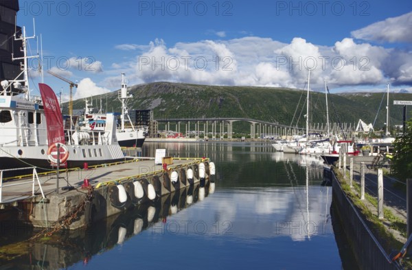 Harbour with boats under blue sky and white clouds, Tromso