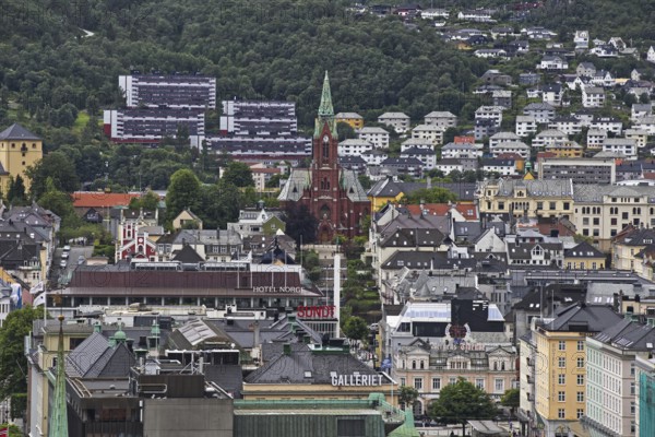 A city view with a church in the center, surrounded by urban architecture and mountains Norway