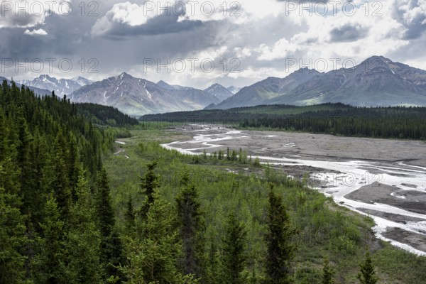 Taiga and tundra with Teklanika River, mountain scenery of the Alaska Range with dramatic cloudy sky, Denali National Park, Alaska, USA