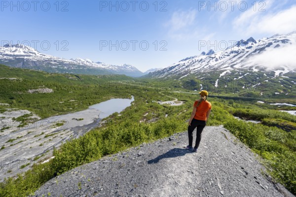 Female hiker on glacial moraine, view of the vast Tsina River valley with mountains, Worthington Glacier Lagoon, Worthington Glacier State Recreational Site, Chugach Mountains, Alaska, USA