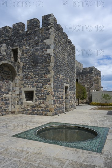 Part of a massive stone castle with battlements and a decorative fountain in the courtyard, Rabati Fortress, Akhaltsikhe, Samtskhe-Javakheti region, Samtskhe-Javakheti, Georgia