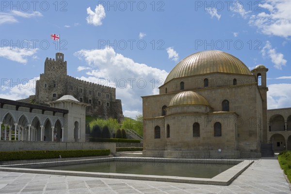 Mosque with golden dome in front of a stone castle with flag under clear sky, Rabati Fortress, Akhaltsikhe, Samtskhe-Javakheti region, Samtskhe-Javakheti, Georgia