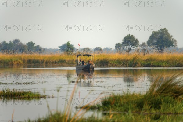 Tourist boat on safari in the lagoon, Xakanaxa Lagoon, Okavango Delta, Moremi Game Reserve, Botswana