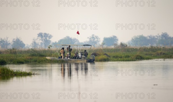 Tourist boat, tourists taking pictures of elephants, Xakanaxa Lagoon, Okavango Delta, Moremi Game Reserve, Botswana