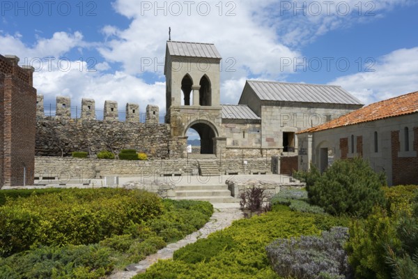 Historic church building with bell tower and adjoining garden under blue sky, Rabati Fortress, Akhaltsikhe, Samtskhe-Javakheti region, Samtskhe-Javakheti, Georgia