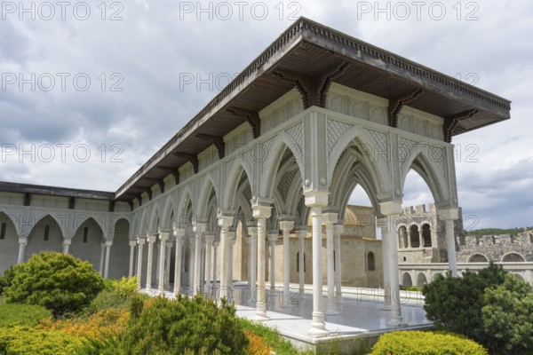 Historical building with decorated portico surrounded by green bushes and cloudy sky, Rabati Fortress, Akhaltsikhe, Samtskhe-Javakheti region, Samtskhe-Javakheti, Georgia