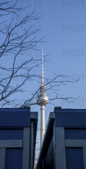 View between two construction containers towards the TV tower at Alexanderplatz, Berlin, Germany