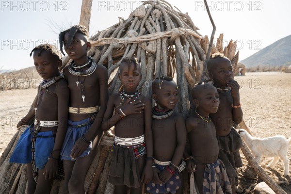 Himba children standing at hut, traditional Himba village, Kaokoveld, Kunene, Namibia