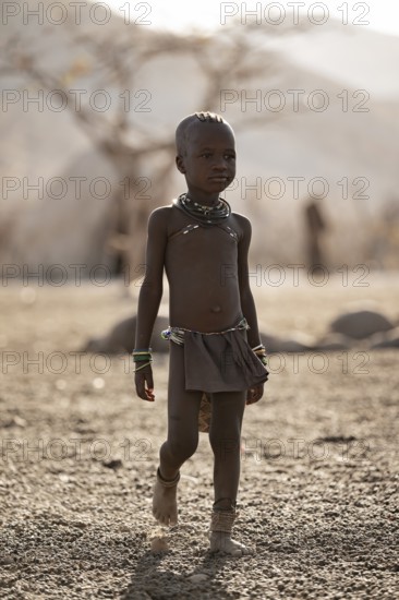 Himba child running in the village, traditional Himba village, Kaokoveld, Kunene, Namibia
