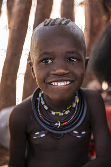 Portrait, grinning Himba child, traditional Himba village, Kaokoveld, Kunene, Namibia