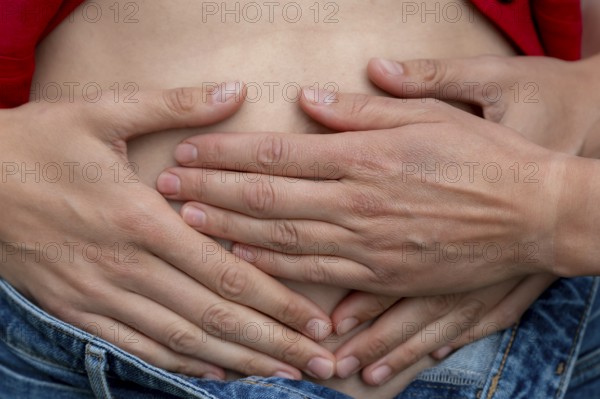 Symbolic picture of pregnancy, hands lying on a woman's stomach