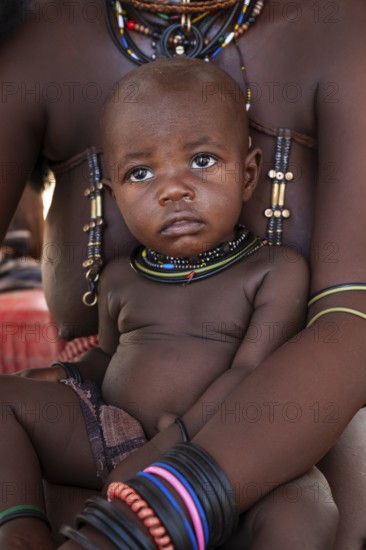 Himba woman with baby, traditional Himba village, Kaokoveld, Kunene, Namibia