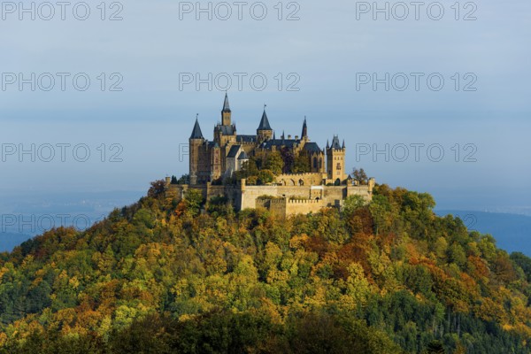 Castle and autumnal forest, Hohenzollern Castle, sunrise, Hechingen, Swabian Jura, Baden-Württemberg, Germany