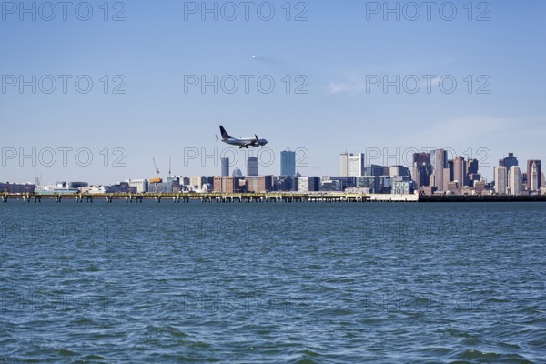 Boston skyline with an airplane landing at Logan International Airport, Boston, Massachusetts, New England, USA