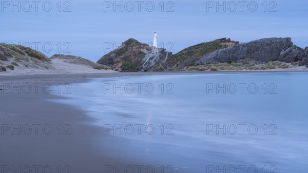 Deliverance Cove and Castlepoint Lighthouse on the rock, ocean, long exposure, evening, illuminated. Castlepoint, Wairarapa Coast, Wellington Region, North Island, New Zealand