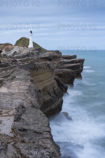 Castlepoint lighthouse on a rock, sea, long exposure. Castlepoint, Wairarapa Coast, Wellington Region, North Island, New Zealand