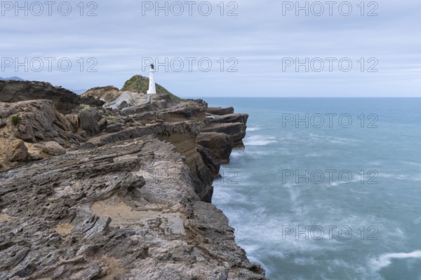 Castlepoint lighthouse on a rock, sea, long exposure. Castlepoint, Wairarapa Coast, Wellington Region, North Island, New Zealand