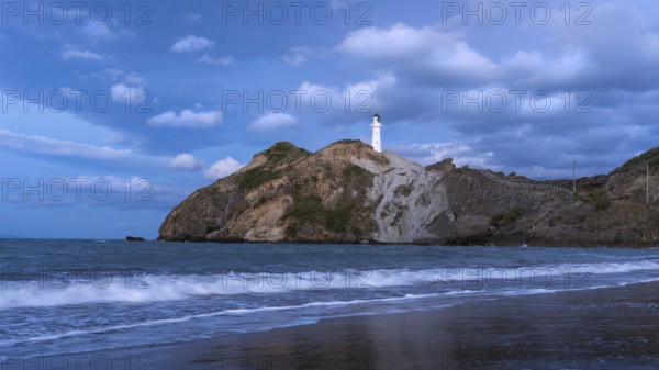 Castlepoint Beach, ocean and lighthouse on a rock, in the evening, after sunset. Castlepoint, Wairarapa Coast, Wellington Region, North Island, New Zealand