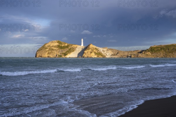 Castlepoint Beach, ocean and lighthouse on a rock, in the evening. Castlepoint, Wairarapa Coast, Wellington Region, North Island, New Zealand