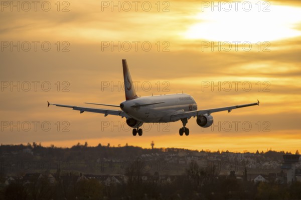 Airplane landing at sunset, orange light on horizon, Stuttgart airport, Leinfelden-Echterdingen, Baden-Württemberg, Germany