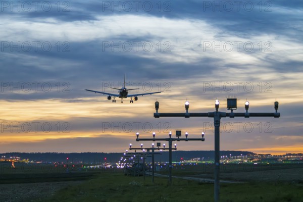 Airplane landing at dusk with illuminated runway, Stuttgart Airport, Leinfelden-Echterdingen, Baden-Württemberg, Germany