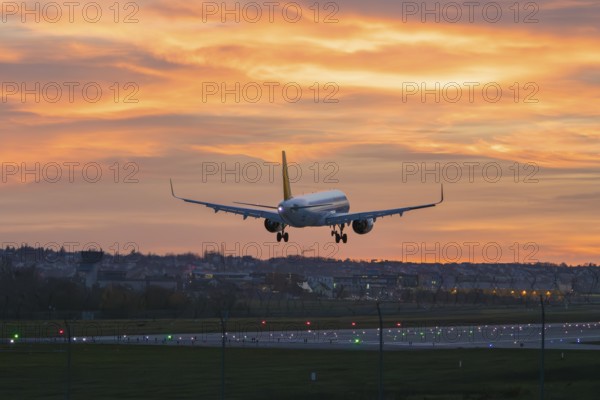 Airplane approaching urban landscape at bright sunset, Stuttgart Airport, Leinfelden-Echterdingen, Baden-Württemberg, Germany